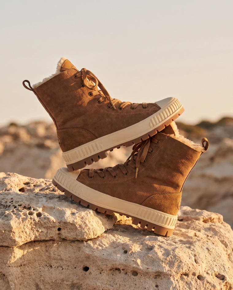 EMU sheepskin boots on limestone at sunset
